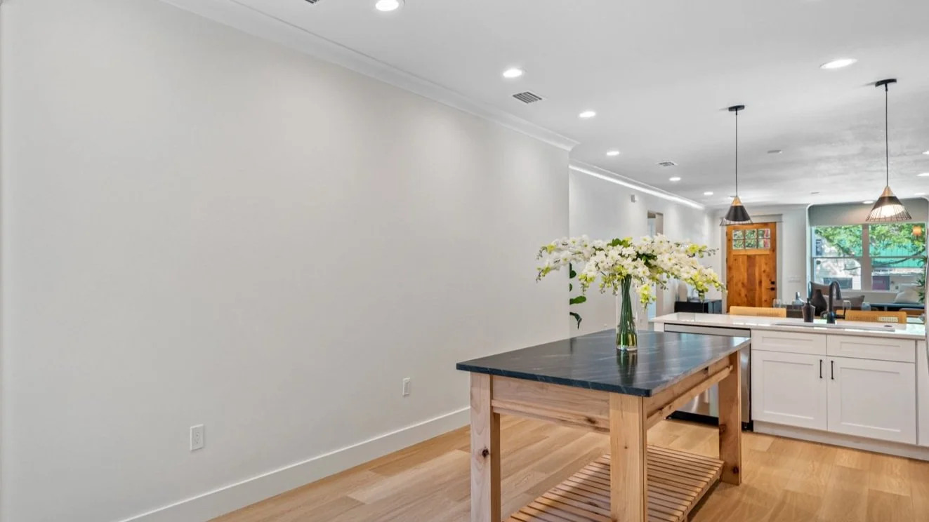 Open plan kitchen and dining with butcher block island and reclaimed wood door