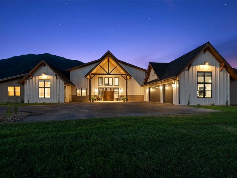 Custom home front entry at night, timber accents and warm lighting