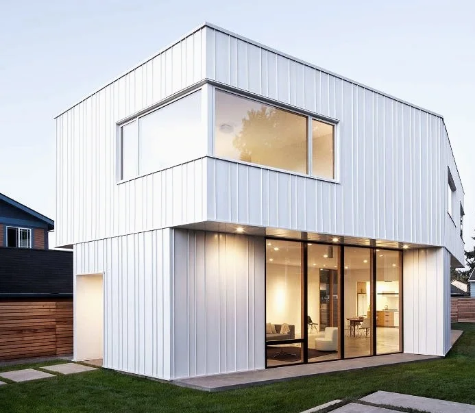 Pavilion House — minimalist white standing seam residence at dusk