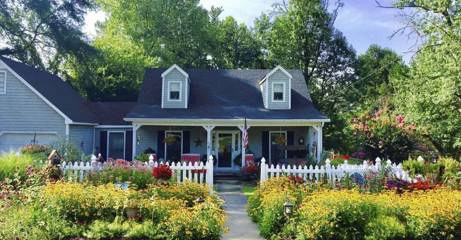 Healthy home exterior — Cape Cod with white picket fence and wildflower garden