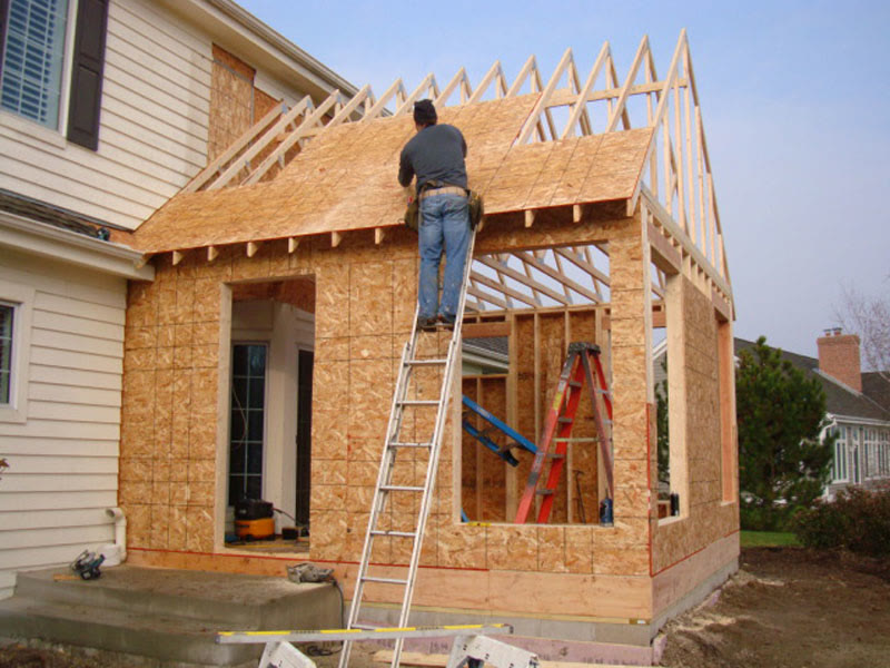 Framing carpenter on ladder at a residential home addition