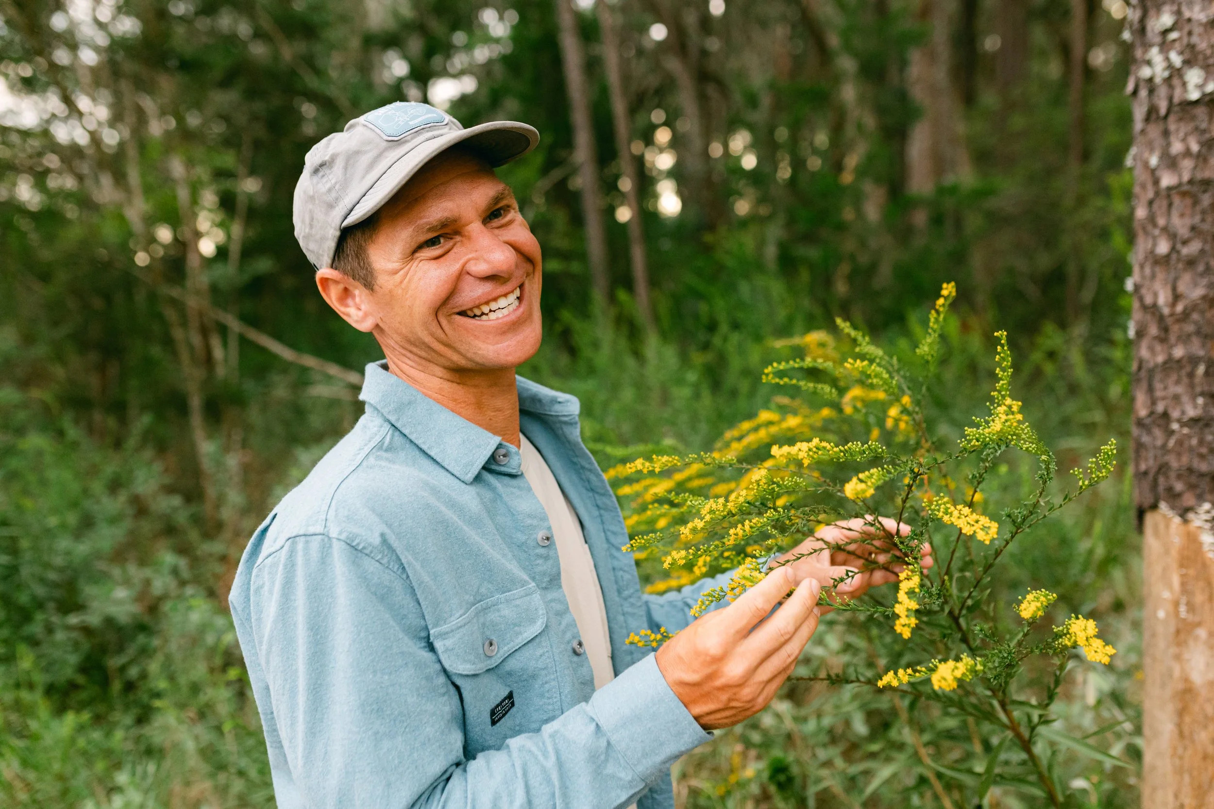 Ryan Riddei examining native wildflowers in a South Carolina forest