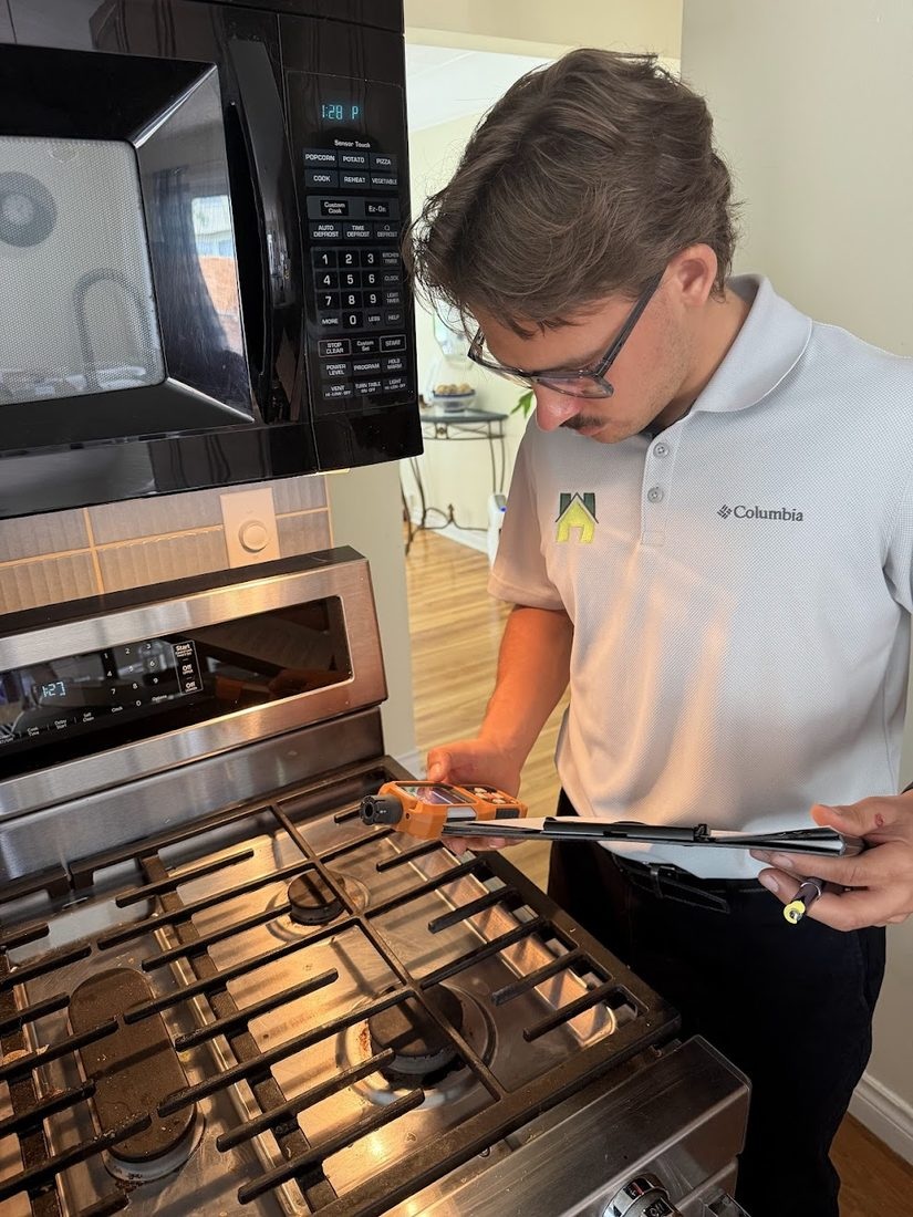 Hunter using a handheld instrument beside a kitchen gas cooktop.