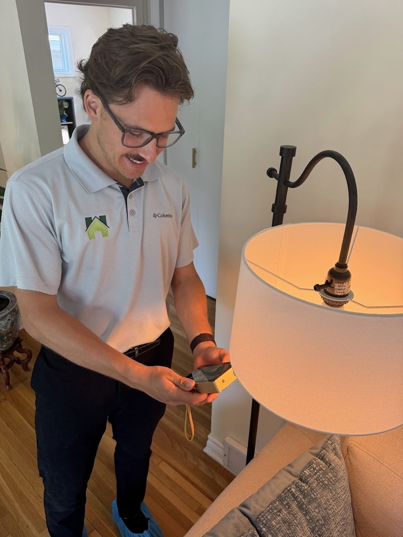 Hunter using a handheld meter beside a table lamp.