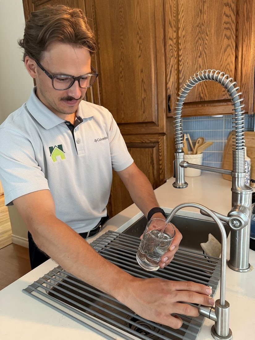 Hunter collecting a water sample at a kitchen sink.