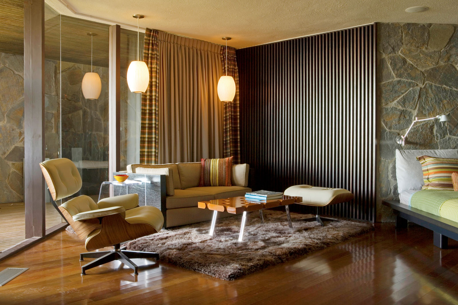 Lautner Wolff House — mid-century living room with stone fireplace and Eames chair