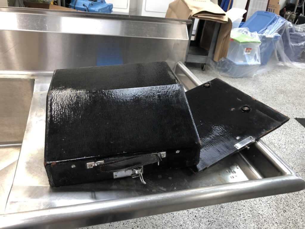 An open black case at a stainless-steel cleaning station