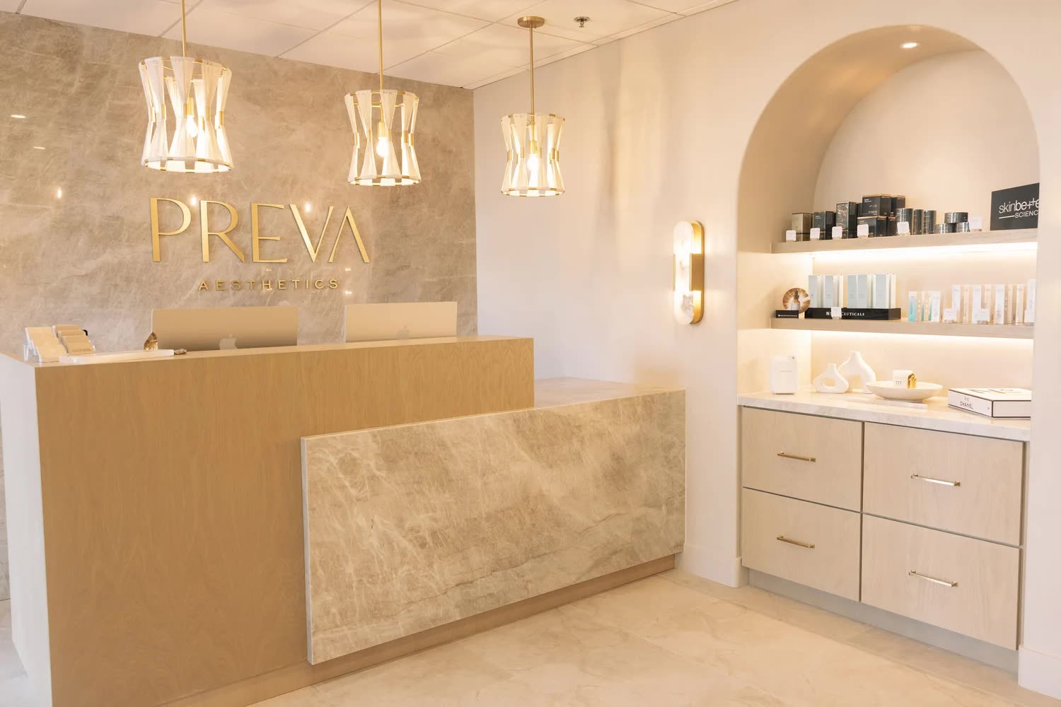 PRIVA medspa reception with travertine finish and arched shelving