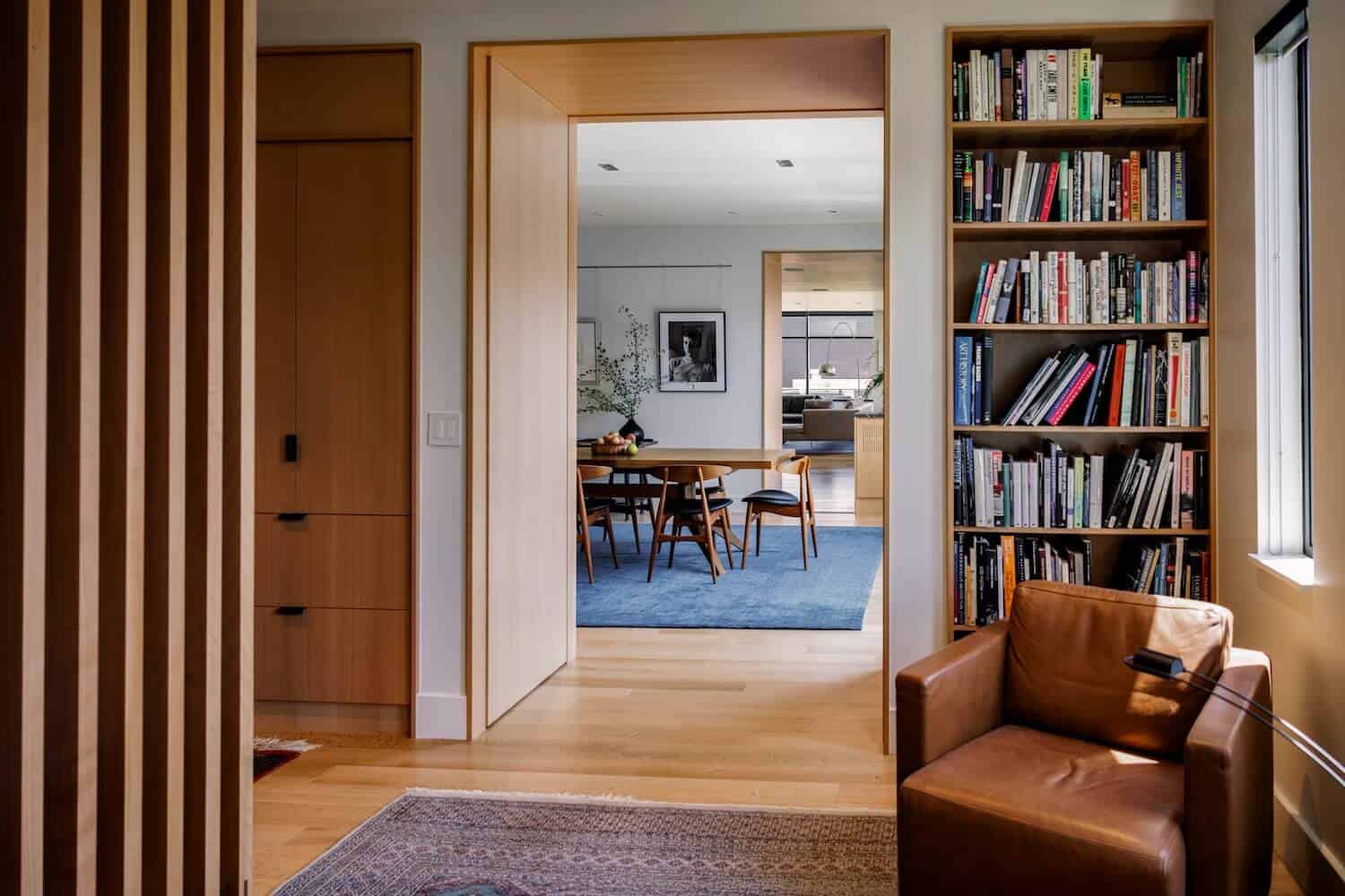Casey Condo Expansion — warm wood interior with bookshelves and dining beyond