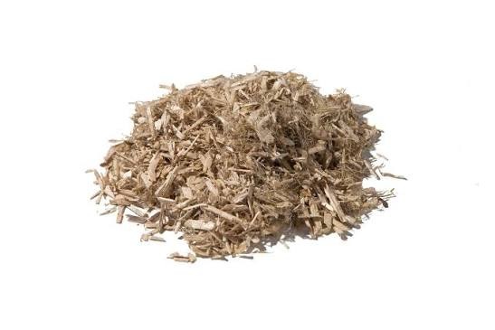 A pile of tan hemp hurd on a white background.