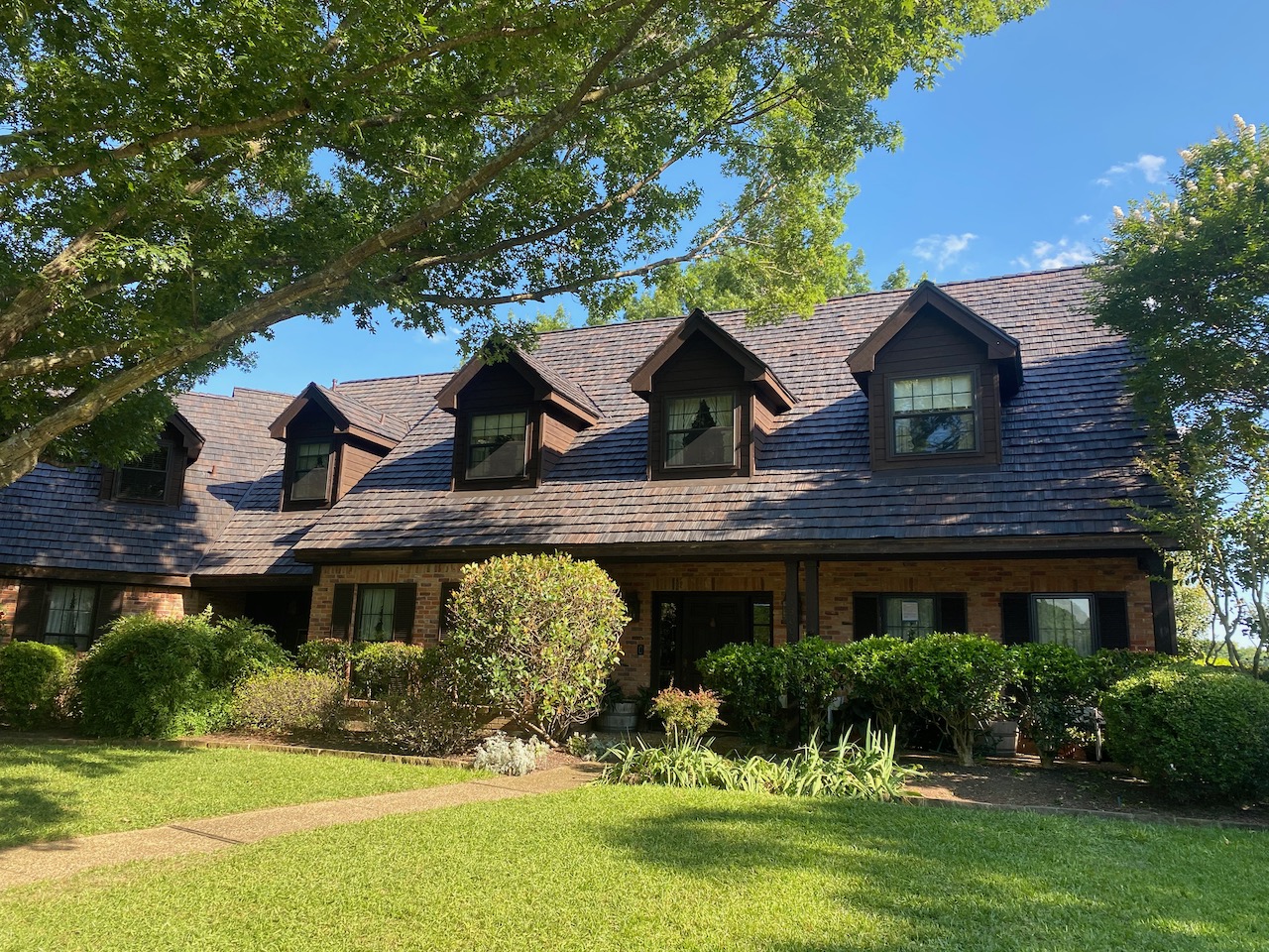 Rustic Brava shake roof on traditional brick home with dormers