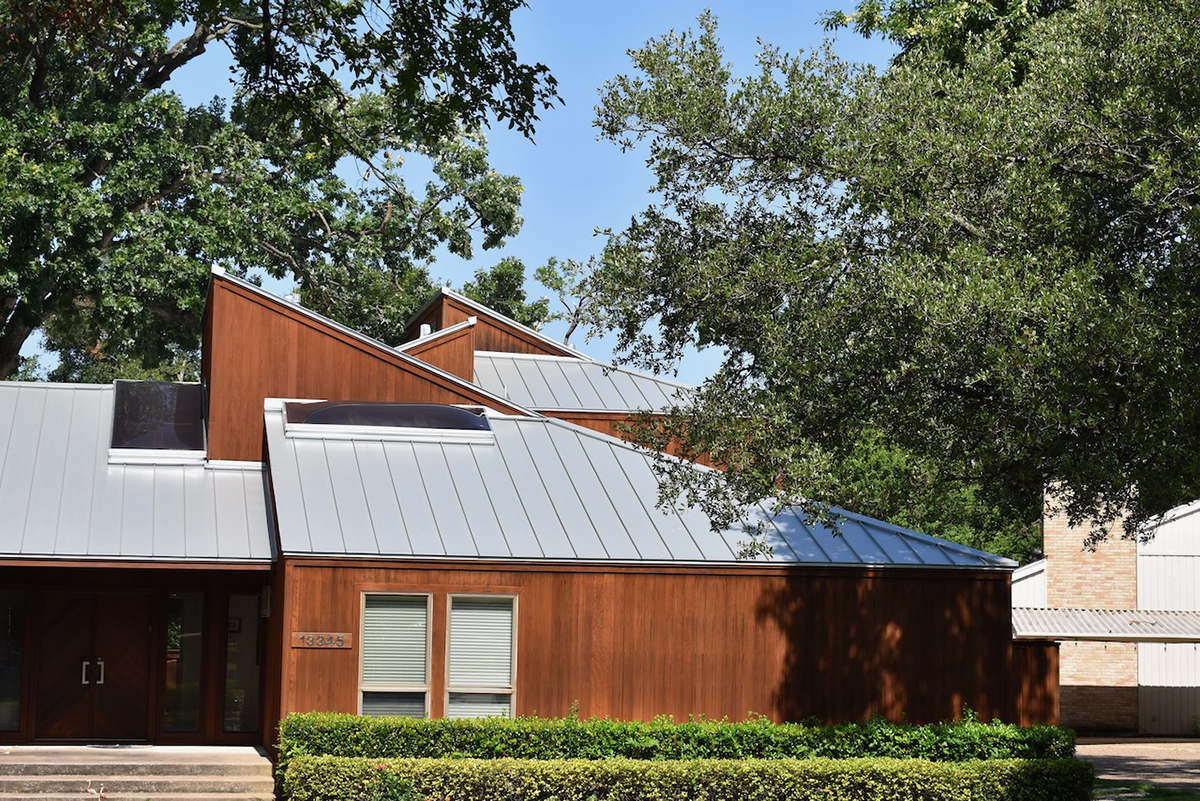 Metallic silver standing seam metal roof on modern cedar home