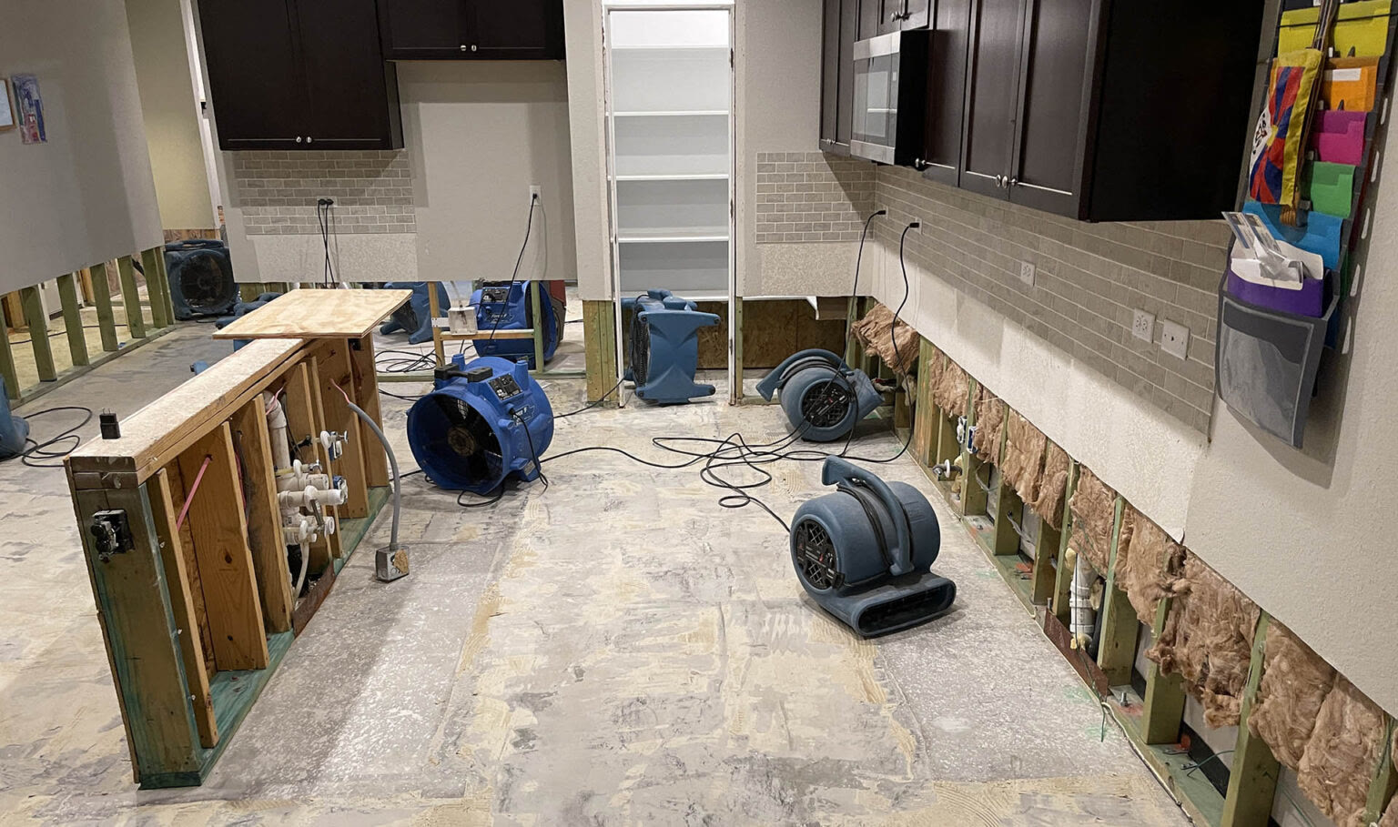 Texas Dry Out water damage restoration jobsite — extracted floor, exposed subfloor, drying equipment in place