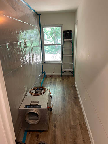 Plastic containment barrier with zipper entry inside a Round Rock home during mold remediation