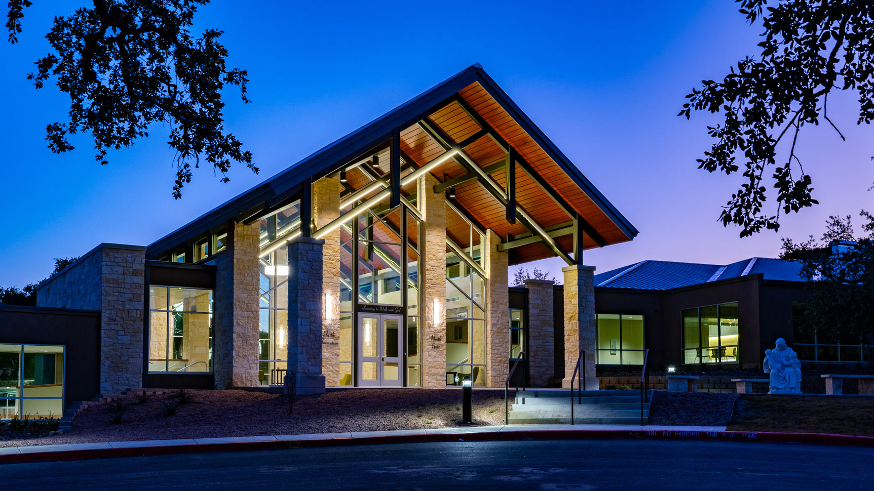 Timber and glass pavilion at twilight, stone columns and warm interior light